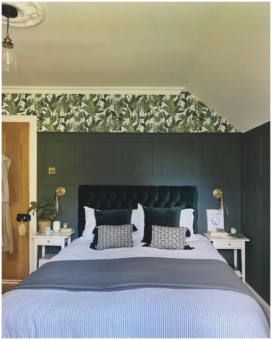 Deep emerald green bedroom with painted panelling in a Victorian home