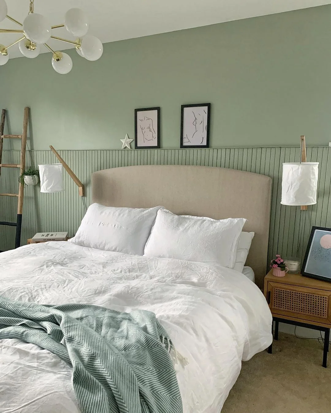 Sage green bedroom with vertical wall panelling and white bedding