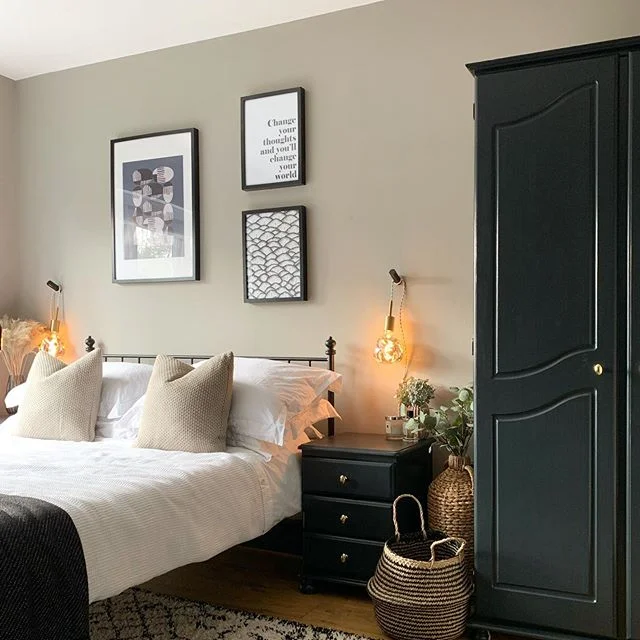 Warm neutral bedroom with black furniture and brass accents painted in Farrow and Ball Worsted