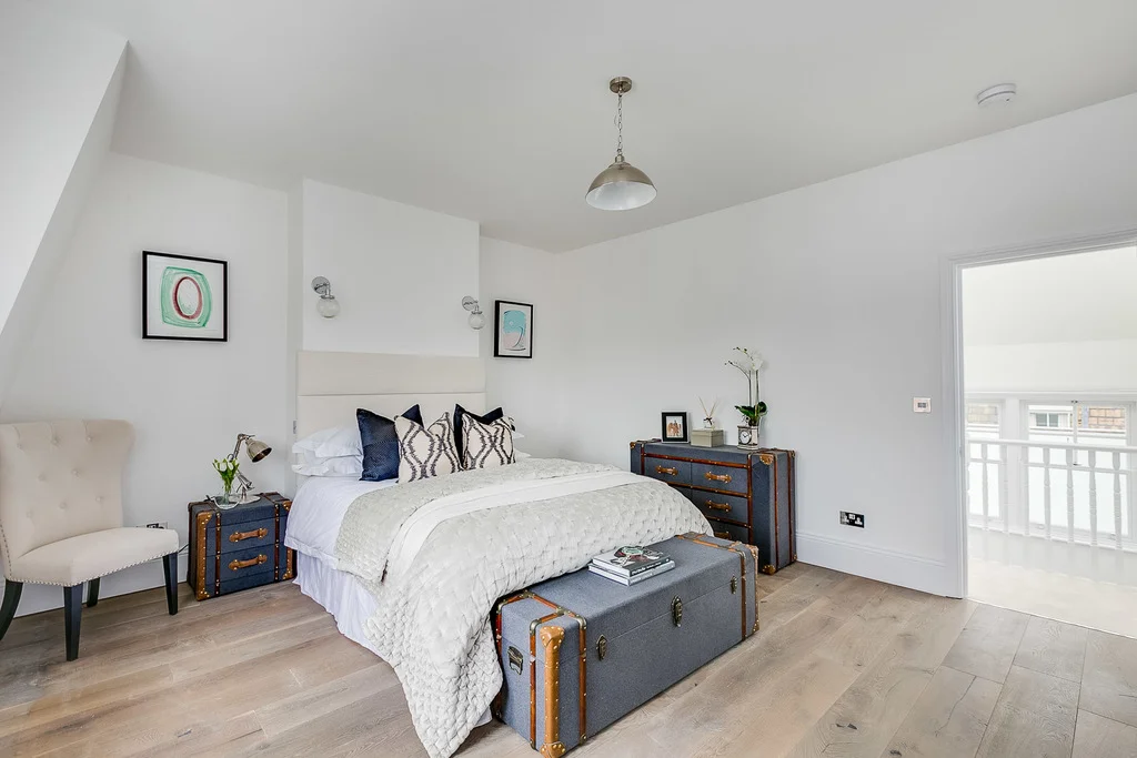 White bedroom colour scheme with cream bedding and blue accent furniture