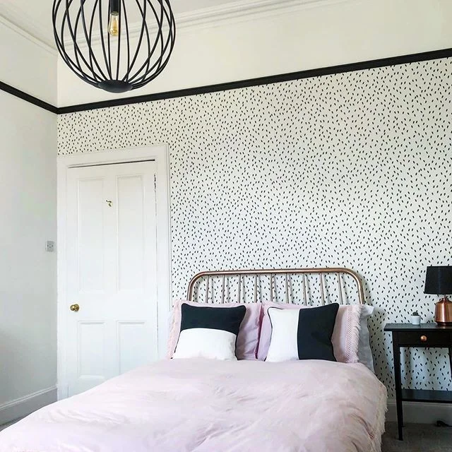 Modern monochrome bedroom with black and white scheme softened by pale pink bedspread